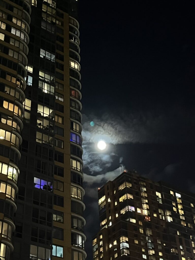 Image of the moon peeking out from the clouds in downtown Brooklyn right outside dumbo, Taken at night.