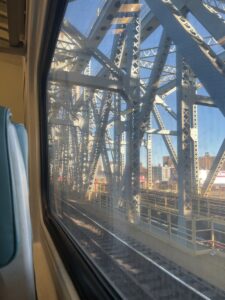 Shot taken by Angela Alvarez, 2023, from the window of a moving Metro North train, on a bridge casted with the sunlight.