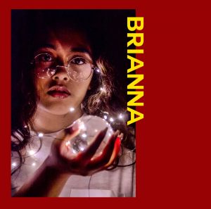 A photo of a girl placed on a red border. The text to the right of the photo is yellow and says "BRIANNA".