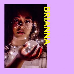 A photo of a girl placed on a purple border. The text to the right of the photo is yellow and says "BRIANNA".