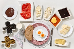 Typical kid's breakfast in Istanbul with brown bread, hardboiled egg, olives, tomatoes, cheese, jam, and honeyed butter.