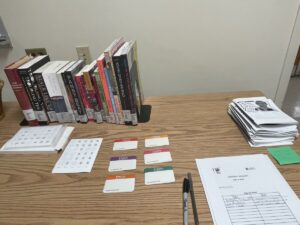 An image of a table filled with books, name tags, pamphlets, and a sign-up sheet for the event. 