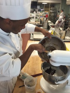 Shaquan adding chocolate to the rest of the meringue and syrup for the Soft Chocolate Nougat.