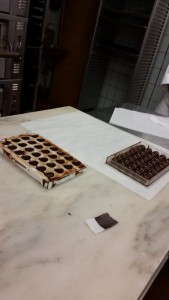 One mold filled with chocolate and the other is flipped over parchment to set.