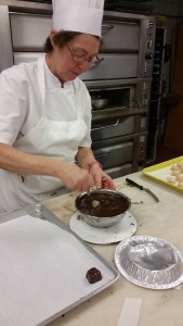 Prof. Hoffman showing the class a demo on dipping chocolate using dipping tools and proper set-up for dipping. 