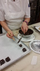 Demo examples of both round and square confection into tempered dark chocolate using the fork dipping tool.