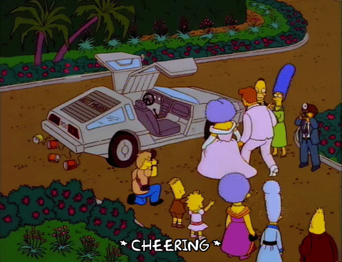 A gif of one of Marge Simpson's sisters in a bridal gown getting into a Delorean with her groom as others look on and cheer.