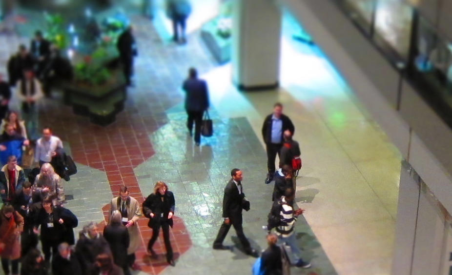 Professionals walking through a convention hall at a conference.