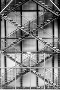 Black and white image of intersecting metal staircases.
