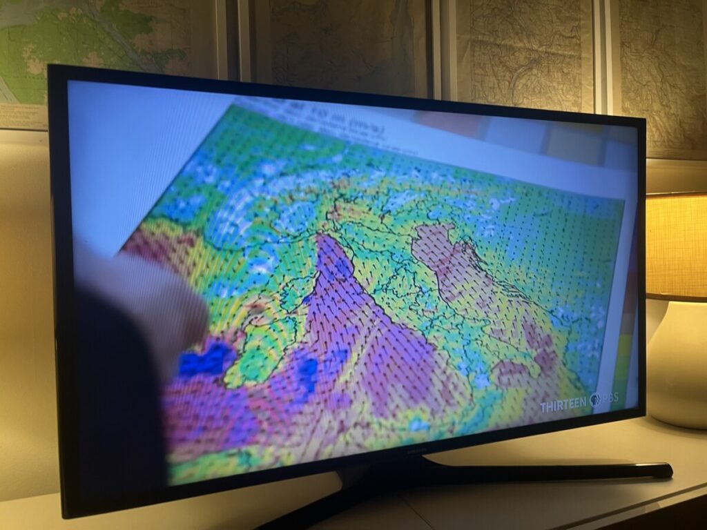 Photo of a TV showing a map with wind direction 