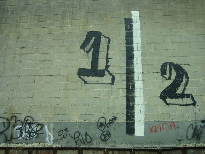 The numbers 1|2 painted on a brick wall painted white