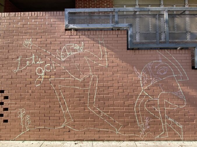 chalk drawing on brick wall, creatures and "Let's go!"