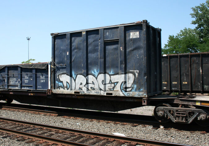 Freight train car with graffiti that reads "DRAFT"