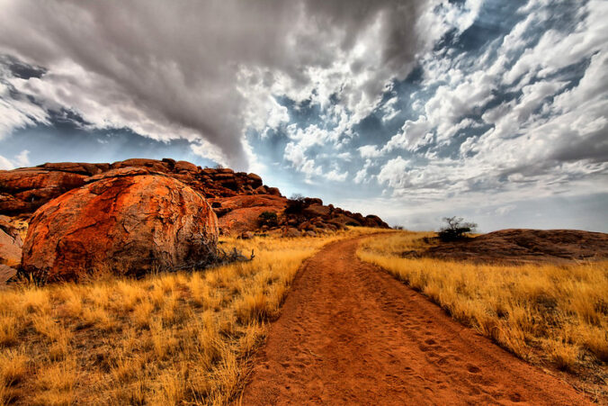 dirt road with clouds overhead