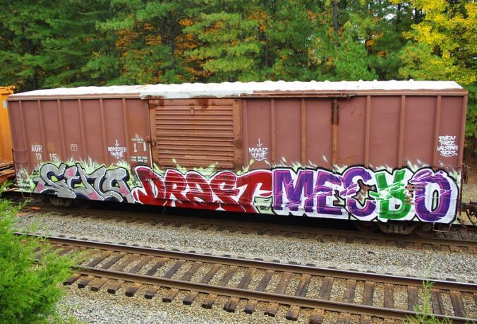freight train with graffiti that reads geno draft mecro