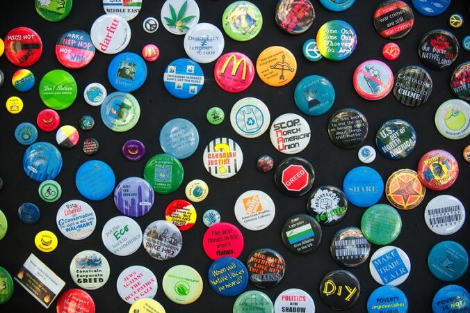 many buttons with logos and slogans on them