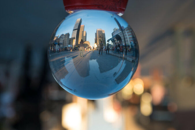Cityscape reflected in a shiny sphere, with blurry lights outside the sphere