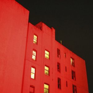 Apartment building with red light shined on it 