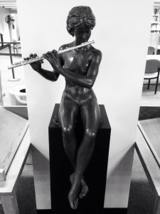 Statue of a woman playing the flute, in City Tech library.