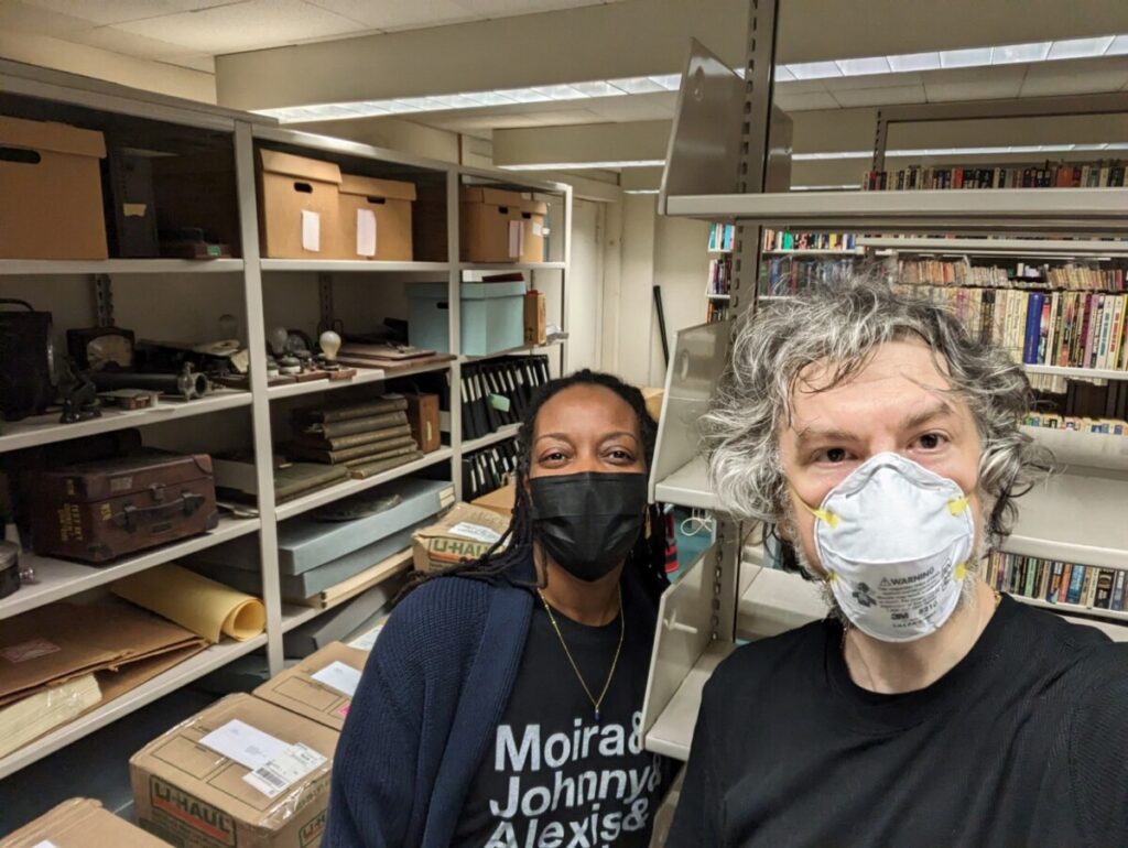 Professors Wanett Clyde and Jason Ellis standing in front of the boxes of newly donated material for the City Tech Science Fiction Collection.