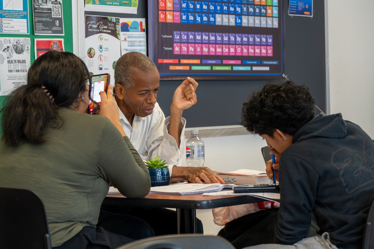 Two students receiving tutoring from a tutor in the SEEK Center for Learning