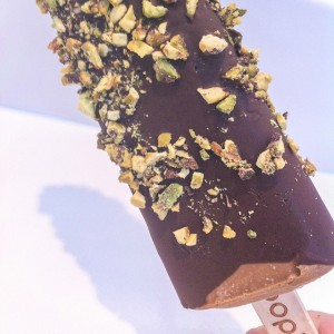 gelato on a stick covered in melted chocolate and pistachios