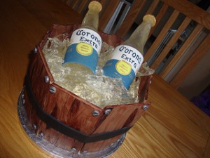 a themed cake of beers being iced in a wooden bucket
