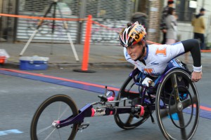 a man running a marathon in a three-wheeled wheelchair