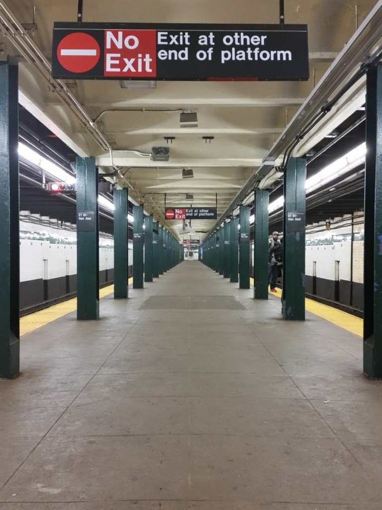 a subway platform with a "No Exit" sign