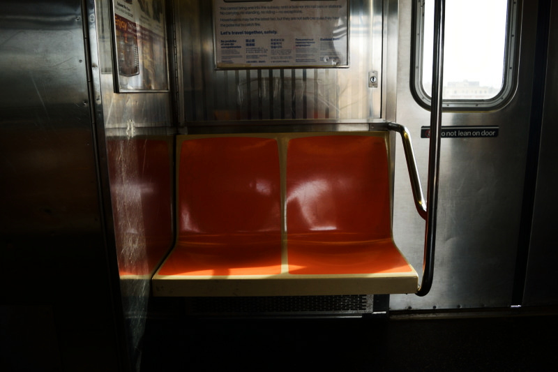 two orange seats on a subway train