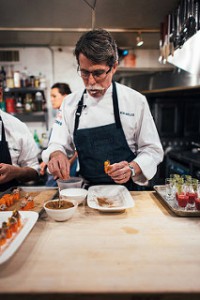 Rick Bayless plating a meal