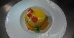 mango mousse plated with kiwi and oranges