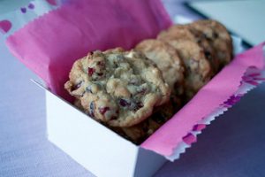 a row of white chocolate cranberry cookies in a box