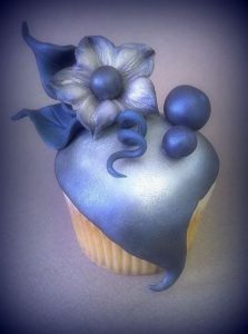 a cupcake covered with fondant flower painted with luster dust