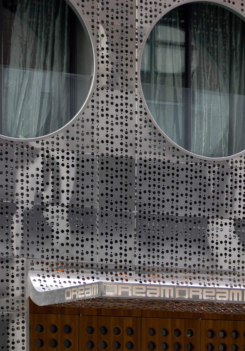 Perforated stainless steel Image-Wall that is produced by Zahner with portholes cut for size