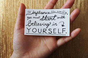 a card that says "To influence the world, you must start with believing in yourself."