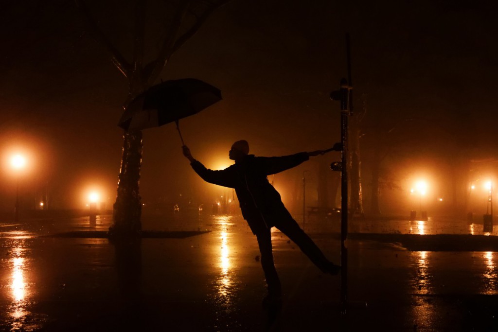 a person holding an umbrella in a park at night