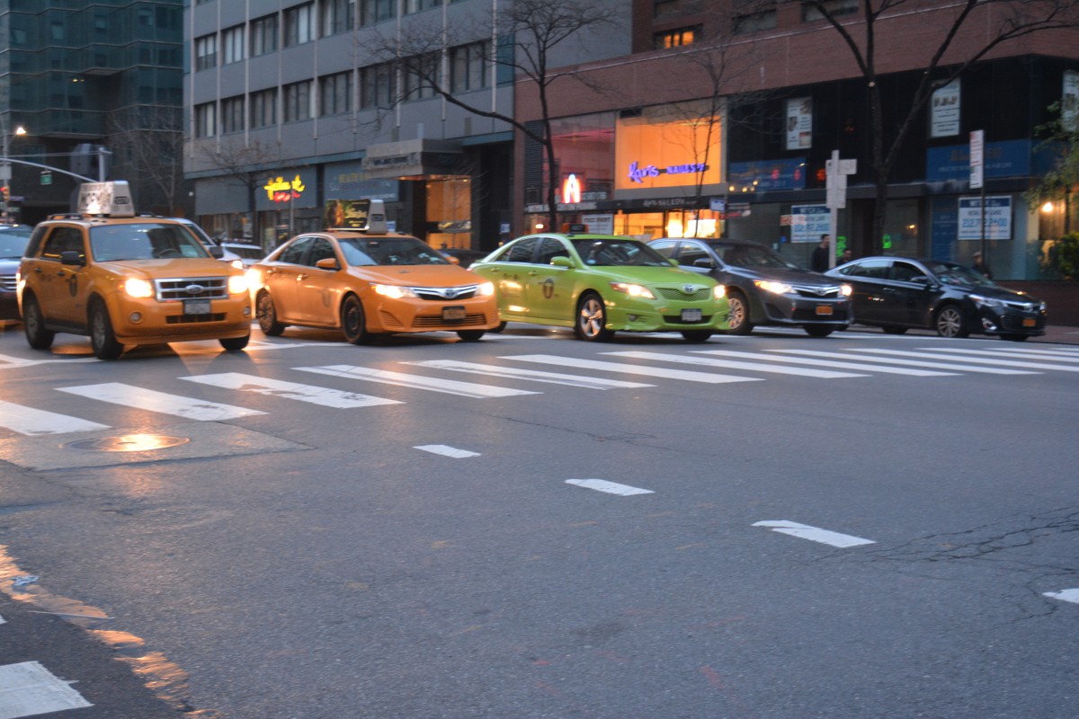 cars lined up at dusk, with headlights on