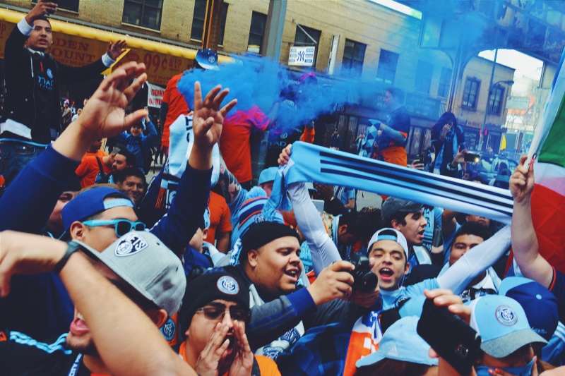 a crowd with blue smoke