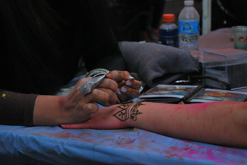 hands getting painted with henna