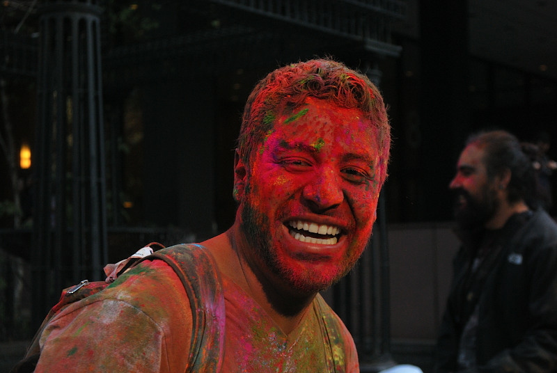 a young man covered in paint, smiling