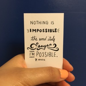 a woman's hand holding a card that says "NOTHING IS IMPOSSIBLE; THE WORD ITSELF SAYS 'I'M POSSIBLE'' 