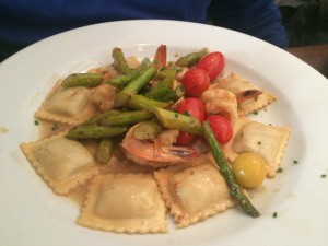 a dish of ravioli with asparagus and tomatoes