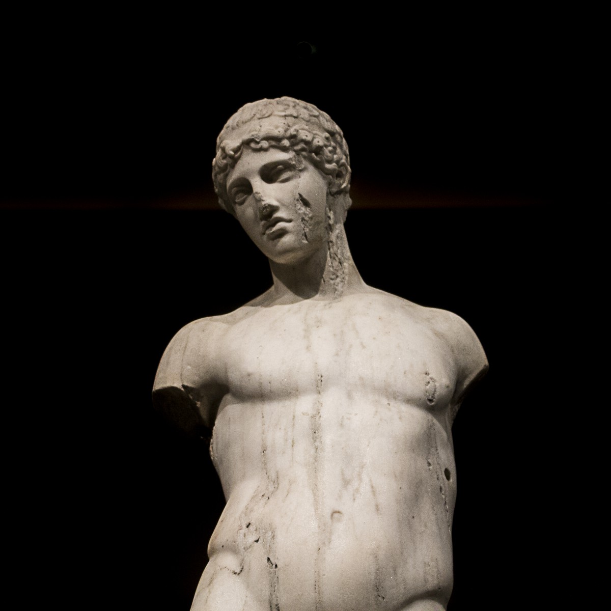 a partly in-tact white marble statue of a person