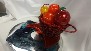 a red basket filled with fruits made entirely out of sugar