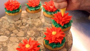 frosting flowers being piped onto a cupcake