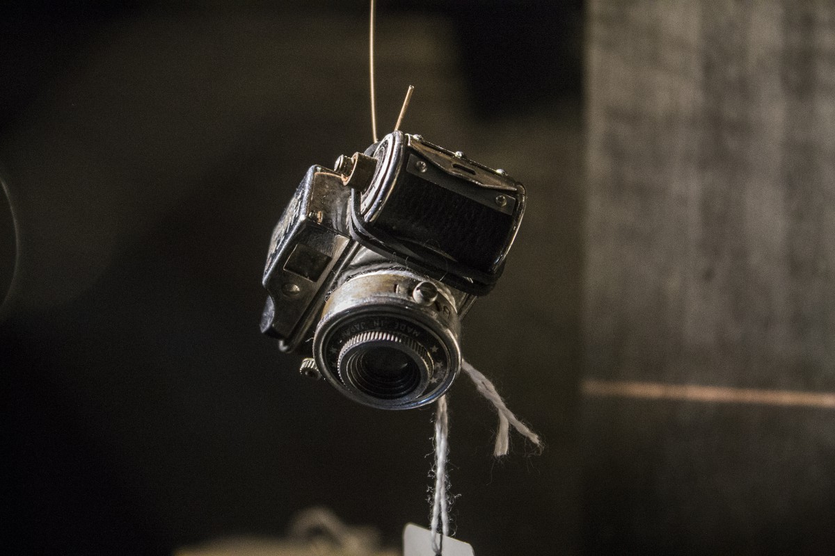 a tiny camera hanging by wire
