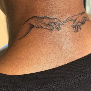 back of someones neck with tattoo of hands almost touching