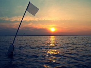 white flag with a sunset background