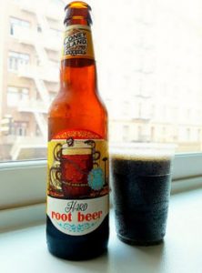 a bottle beside a plastic cup of root beer
